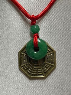 "Green Jade Donut with Taiji Bagua and Yin Yang charm Necklace. Jade donut means Wealth, Peaceful and Protection. Taiji Bagua with 8 Trigrams and Yin Pang Charm for live in harmony with the energies. Good for Feng Shui. This is a good luck necklace special for you, families and friends. Necklace Length is adjustable up to 24\". Material : Jade Donut, Jade Ball , Brass Coin and Nylon Cord Jade color : Green, Bagua color : Brown , Necklace Cord : Black and Red Size : Jade Donut - 15mm round, Jade 8 Trigrams, Green Jade Necklace, Luo Binghe, Yin Yang Charm, Friends Necklace, Luck Necklace, Drip Drop, Good Luck Necklace, Jade Color