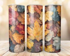 three metal cans with leaves painted on them