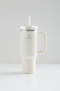 a white coffee cup with a straw in it