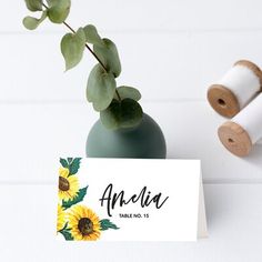 a table number with sunflowers on it next to two spools of twine