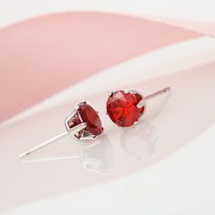 Give your loved one some EXTRA sparkle! Red Cubic Zirconia Earrings specs: 6mm red Cubic Zirconia stud earrings, with 14K white gold dipped settings & post. Red Brilliant Cut Earrings For Anniversary, Red Prong Set Earrings For Valentine's Day, Red Prong-set Earrings For Valentine's Day, Valentine's Day Red Earrings With Prong Setting, Round Lab-created Ruby Earrings For Gift, Lab-created Ruby Earrings For Gift, Classic Red Earrings For Valentine's Day, Red Cubic Zirconia Birthstone Earrings, Red Round Cut Birthstone Earrings