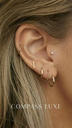 a woman's ear with two small gold hoops