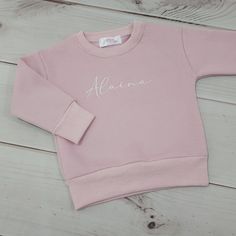 Our personalised jumpers are made from cotton featuring a cuffed waist and wrist cuffs for added warmth and comfort.  Soft and fluffy on the inside and smooth outside appearance, our jumpers can be personalised to your preference.  Sizes are an accurate and comfortable fit. If you are after a more specific or custom embroidery design, please contact us to discuss the options. Winter Long Sleeve Sweatshirt With Name Print, Winter Name Print Relaxed Fit Sweatshirt, Winter Crew Neck Sweatshirt With Name Print, Winter Sweatshirt With Name Print In Relaxed Fit, Personalised Jumpers, Knitted Baby Blanket, Pink Jumper, Wrist Cuffs, Baby Boutique