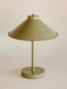 a lamp that is sitting on top of a table with a white wall in the background