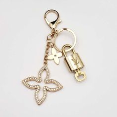 a gold keychain with a lock and flower design on it's side