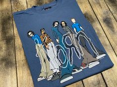 a t - shirt with an image of four people standing on top of each other