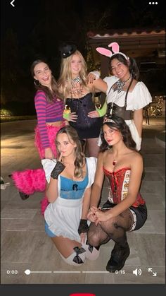 several women dressed up in costumes posing for a photo