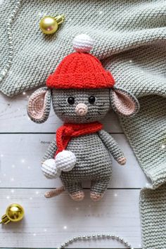 a knitted mouse with a red hat and scarf