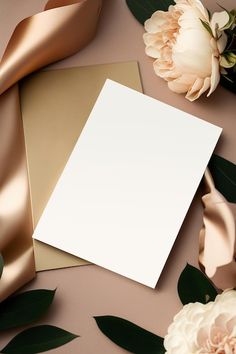 an empty card surrounded by flowers and satin ribbons