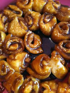 there are many doughnuts that have been glazed in brown sauce on the plate