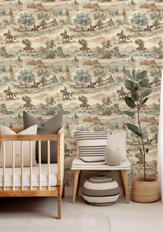 a baby's crib in front of a wallpaper with horses on it