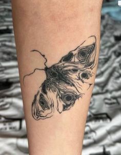 a black and white butterfly tattoo on the leg