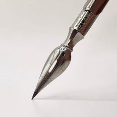 a silver pen sitting on top of a white table