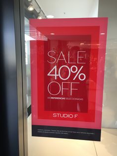 a red sale sign hanging on the side of a glass door