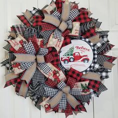 a red and black christmas wreath hanging on a door