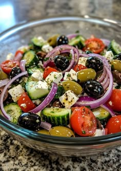 a glass bowl filled with lots of different types of vegetables