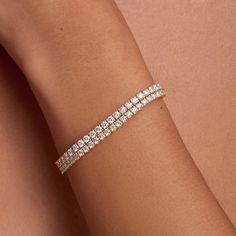 This Tennis Bracelet features an elegant round shape and a sparkling design. This bracelet is designed to be durable and long-lasting. The bracelet's unique sparkle makes it the perfect accessory for any occasion. The standard size is 7 inches; please note any other sizes are considered special order and may require additional time for production. Flexible Round Cut Tennis Bracelet For Anniversary, Elegant Sparkling Bracelets For Anniversary, Flexible Diamond White Cubic Zirconia Tennis Bracelet, Classic Flexible Jewelry In Diamond White, Elegant Flexible Tennis Bracelet, Round Diamond Bracelet Fine Jewelry, Flexible Diamond Tennis Bracelet For Anniversary, Elegant Sparkling Diamond Bangle Bracelet, Sparkling Round Diamond Bracelet Fine Jewelry