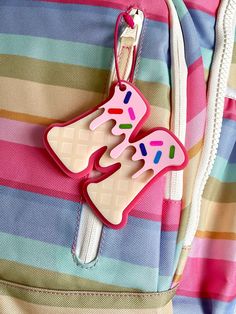 a pink and white bag with a plastic object in the shape of a butterfly on it