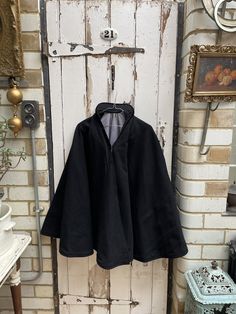 Antique Dutch handmade black wool fishermans cape with blue lining and stand up collar one size. Dutch, circa 1890. 100% Wool. Rigid stand up collar, black wool exterior with blue wool lining, hook & eye fastening. Size: Length: 34 inches (from top of collar to hem). Weight: allow 5 kg volumetric weight once packed. Good condition for its age. Great costume for play or theatre production (if not to be worn). Vintage Black Cape For Winter, Black Wool Cape Poncho, Vintage Black Winter Cape, Black Cape For Larp, Cottagecore Apothecary, Theatre Production, Dark Cottagecore, Stand Up Collar, Charity Shop