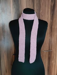 a pink knitted scarf sitting on top of a mannequin