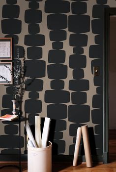 black and white wallpaper in a living room with two stools next to it