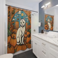 a white cat sitting on top of a shower curtain next to a sink and toilet