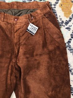 "Vintage cinnamon-brown suede pants. High rise with pleats, these pants have a great Jim Morrison vibe! No tags indicating size or make, measures 15\" waist, 24\" hips, 12\" rise, 37.5\" long." Brown Tapered Leg Bottoms For Fall, Brown High-waisted Leather Pants For Winter, Brown Leather Trousers For Winter, Suede Bottoms For Workwear In Fall, Vintage Brown Winter Pants, Brown Vintage Pants For Winter, Suede Pants For Workwear In Fall, Brown Suede Pants For Fall, Casual Brown Suede Bottoms