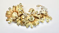 Beautiful and big signed Miriam Haskell brooch - probably dating to the 1950's. Composed of several large flowers with citrine rhinestones and surrounded by textured gold metal leaves. The leaves capture a great deal of movement and lend beauty to this classic Haskell piece. Under the flower layer is a diamante layer in clear rhinestones on top of filagree leaves. Filagree backing with rollover clasp and an oval plaque signed Miriam Haskell. The pin bar opens to 45 degree angle. Great condition, Miriam Haskell Jewelry, Floral Brooch, Miriam Haskell, Metal Leaves, Small Leaf, Brooch Vintage, Pearl Brooch, Fabulous Jewelry, Enamel Flower