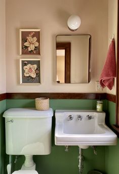 a white sink sitting under a mirror in a bathroom next to a green counter top