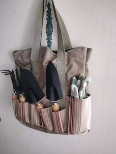 a tote bag hanging on the wall with several pairs of shoes and umbrellas in it