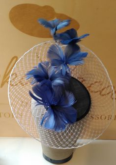 Blue feather flowers fascinator. This exquisite hat consists of a  blue base, with veil brim and a delightful blue feather flowers. When ordering this hat please mention your hair colour, and the hair band will be covered in a handled silk to match your hair, making it invisible. This beautiful hat is perfect for mother of the bride or wedding guest Love this look, but need it in another colour to match your outfit, send us an photograph of your outfit and state the colours you would like for the sinamay, ceiling and feathers See colour chart. There will be a £25 surcharge for bespoke items. We look forward to hearing from you. Blue Handmade Flowers Fascinator For Races, Blue Fascinator With Handmade Flowers For Kentucky Derby, Blue Fascinator For Royal Ascot Garden Party, Blue Fascinator For Garden Party And Royal Ascot, Blue Fascinator For Garden Party At Royal Ascot, Elegant Blue Fascinator With Handmade Flowers, Blue Fascinator For Kentucky Derby Garden Party, Blue Hats With Handmade Flowers For Royal Ascot, Blue Mini Hats With Handmade Flowers For Royal Ascot