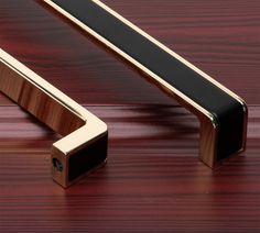 a close up of a wooden door handle on a wood table with a red background