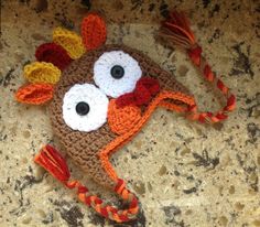 a crocheted turkey hat with eyes and tail