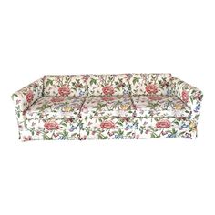 a white couch with pink flowers on it and green leaves around the edges, sitting in front of a white background