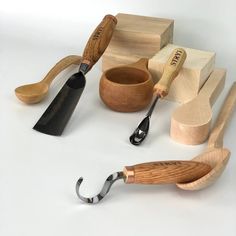 wooden kitchen utensils are arranged on a white surface