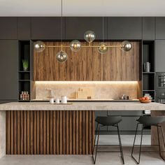 a modern kitchen with an island counter and bar stools in the middle of it