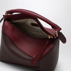 Let me tell you about this charming little bag that's as stylish as it is versatile. It's the kind of accessory that seamlessly transitions from day to night, all while being perfectly chic. Trust me, it's a must-have for anyone who loves a touch of luxury in their everyday life. Crafted from rich cremson and dark burgundy satin calfskin leather Tone-on-tone piping for a subtle, elegant look Convenient top zip fastening to keep your essentials secure Comes with a leather handle and an adjustable Leather Small Bag, Loewe Puzzle Bag, Loewe Puzzle, Puzzle Bag, Dark Burgundy, Leather Cap, Mini Shoulder Bag, Beach Tote Bags, Small Handbags