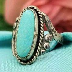 Southwestern-STYLE Sterling Silver Skinny Oval Turquoise Ring with Twisted Border Detail- Beautifully Crafted.  Made in the 1970s.  This True Vintage Piece features a Natural, Skinny Oval  Turquoise Gemstone that has Beautiful Marble Detail.  The Ring Itself is Made from Solid and Stamped  Sterling Silver with a Twisted Border Surrounding the Stone.  The Turquoise measures 15.5mm in Length 6mm Wide The Face of the Ring measures 13/16'' in Length 3/8'' Wide The Band measures 3.1mm in Width Split Southwestern Style Ring With Patina, Adjustable Southwestern Style Ring With Patina, Bohemian Turquoise Concho Ring, Bohemian Oval Turquoise Ring With Patina, Western Style Turquoise Ring Collectible, Southwestern Blue Turquoise Ring With Patina, Antique Turquoise Adjustable Rings, Adjustable Blue Turquoise Ring In Western Style, Adjustable Western Style Blue Turquoise Ring