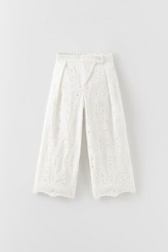 Pants with back elastic waistband and front crossover button closure. Swiss embroidery motif and uneven hem. WHITE | 1200/323 OUTER SHELL: 95% cotton · 5% polyester LINING: 100% cotton White Casual Pants With Floral Embroidery, Casual White Pants With Floral Embroidery, White Wide-leg Pants With Floral Embroidery, White Floral Embroidered Wide-leg Bottoms, White Cotton Bottoms With Floral Embroidery, White Ankle-length Pants With Floral Embroidery, Casual Cotton Bottoms With Broderie Anglaise, Spring Cotton Bottoms With Broderie Anglaise, White Cotton Pants With Floral Embroidery