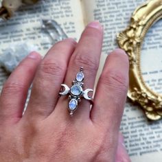 moon ring, witchy jewelry, moonstone ring, crescent moon, moon witch, lunar love, crystal jewelry, fantasy jewelry, silver ring, ooak ring Three moonstones sit in a line and are flanked by two crescent moons. The moons have been textured to add that extra contrast to the shiny stones.  The ring is a size 7 US.  All components of the ring and hand fabricated in sterling silver and plated with 18k white gold.  The back settings of the stones are open to allow natural light to pass through.  Please message me if you have any questions! Silver Moon-shaped Celestial Moonstone Ring, Silver Celestial Moonstone Ring, Celestial Silver Moonstone Ring, Silver Moonstone Ring With Moon Phase, Mystical Sterling Silver Moonstone Ring With Moon Phase, Silver Moon Phase Crystal Ring, Celestial Moon-shaped Moonstone Ring In Sterling Silver, Magical Moon Shaped Ring With Moon Phase Detail, Spiritual Sterling Silver Moon Crystal Ring