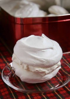 a close up of a plate of food on a table with a red container in the background