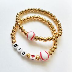 two beaded bracelets with gold balls and i love you written on them,