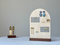 a pair of earrings are hanging on a pegboard with earring holders attached to it