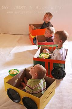 three small children are sitting in toy cars