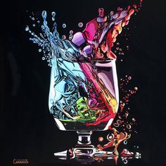 a glass filled with colorful liquid on top of a table