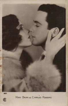 an old black and white photo of two people kissing