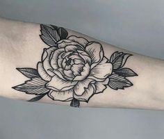 a black and white rose tattoo on the arm