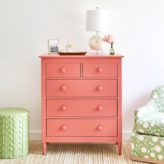 a pink dresser next to a green chair