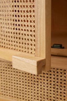 a close up view of a wooden cabinet with perforated mesh on the door