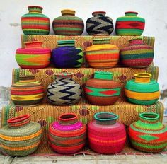 colorful baskets and vases stacked on top of each other